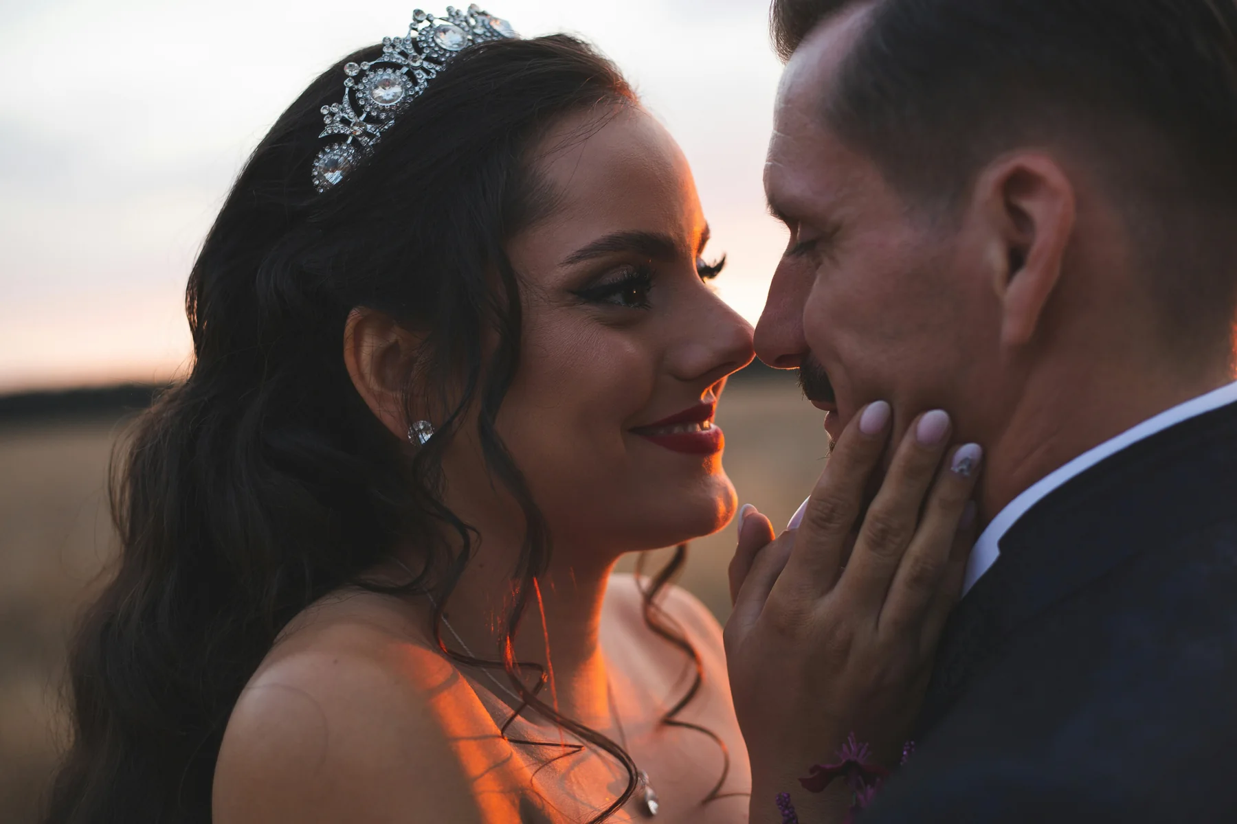 Bride and groom sharing a close moment at sunset